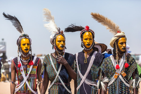 Homens wodaabecom rostos pintados de amarelo em festival típico da cultura africana.