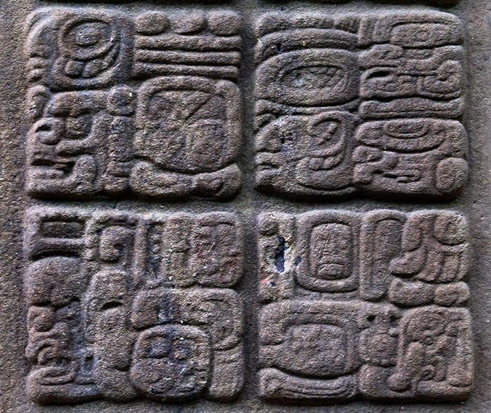 Exemplo de glifos maias esculpidos em uma estela na Guatemala.