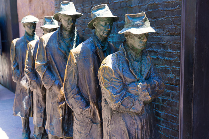 Estátuas de homens com chapéus em monumento sobre uma das crises do capitalismo financeiro.