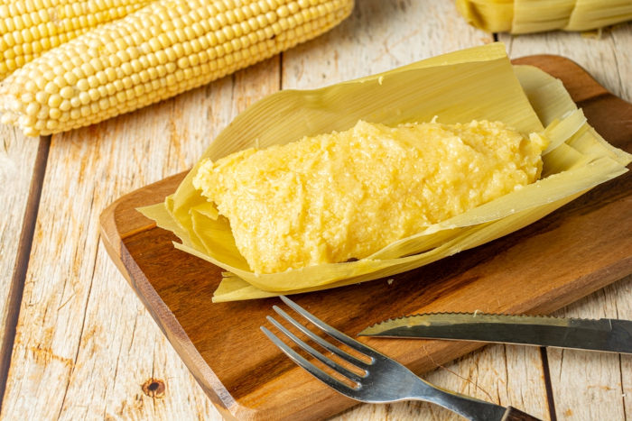 Pamonha sobre uma tábua de madeira, uma das comidas de Festa Junina.