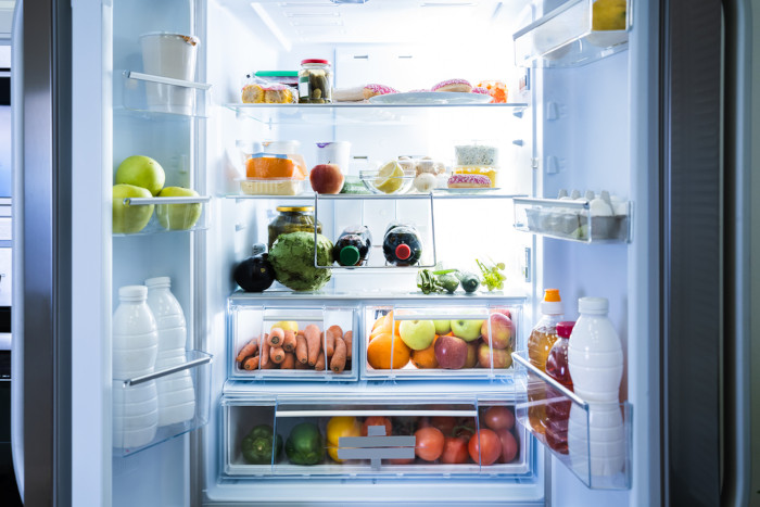 Refrigerador aberto com vários alimentos, uma das aplicações da cinética química no cotidiano.