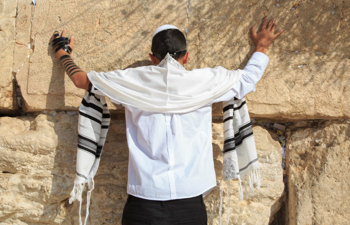 Garoto de 13 anos faz oração no Muro das Lamentações, uma prática do judaísmo.