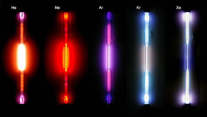 Cinco gases nobres emitindo luzes de cores diferentes.