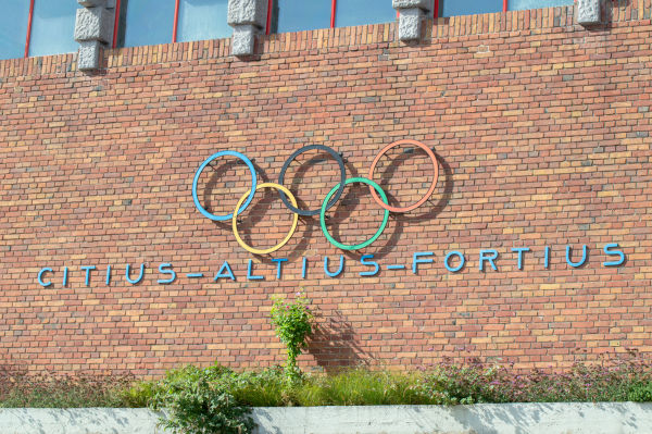 Lema olímpico abaixo dos anéis olímpicos, dois dos principais símbolos olímpicos.