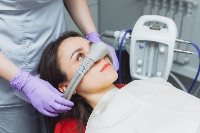 Dentista preparando paciente para inalação de óxido nitroso.