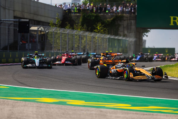 Carros competindo na pista em evento da Fórmula 1, uma alusão à aerodinâmica.