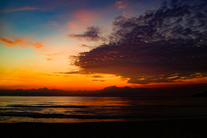 Céu com tons de azul, de vermelho e de laranja ao entardecer.