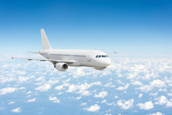 Avião voando no céu, uma alusão à Mecânica, cujo estudo possibilitou o desenvolvimento dos aviões.