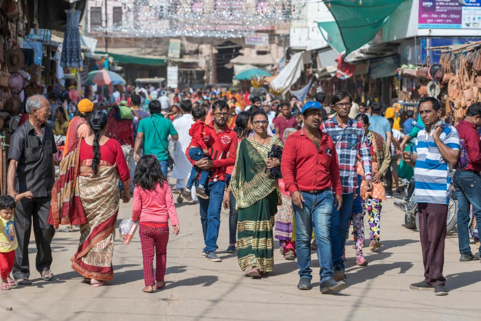 Diversas pessoas caminhando em um mercado de rua da Índia, atualmente, o país mais populoso da Ásia.