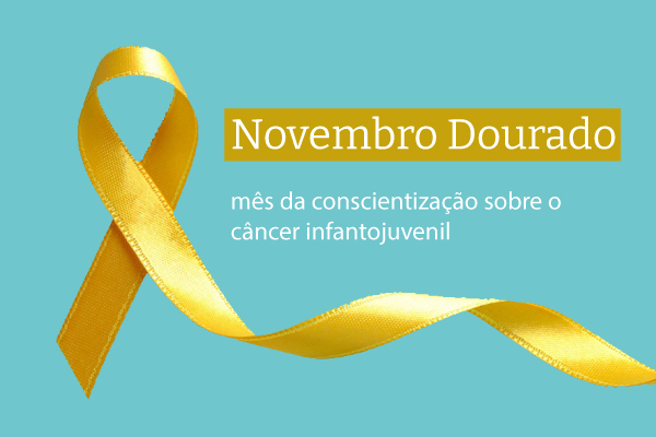 Fita dourada próxima aos escritos “Novembro Dourado” e “mês da conscientização sobre o câncer infantojuvenil”.