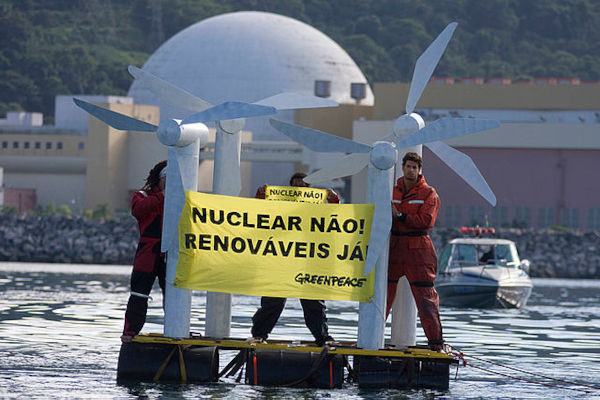 Ativistas do Greenpeace em uma balsa, segurando faixa de protesto contra a usina nuclear de Angra dos Reis.