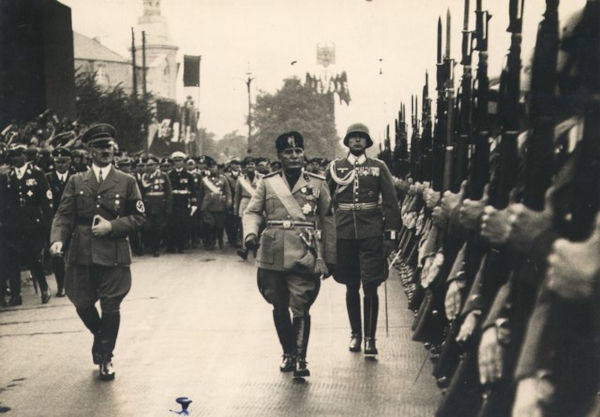 Na foto, Benito Mussolini, líder do fascismo italiano, inspecionando tropas. Do outro lado, o líder do nazismo, Adolf Hitler.