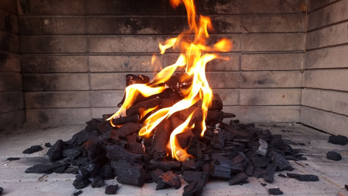 Fogueira feita com carvão vegetal, que se difere do carvão mineral.