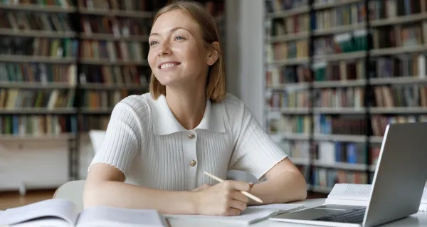 estudante loira com livros e notebook