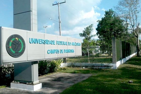 Entrada do campus universitário de Parintins da UFAM com grande estrutura horizontal em concreto com o nome da universidade.